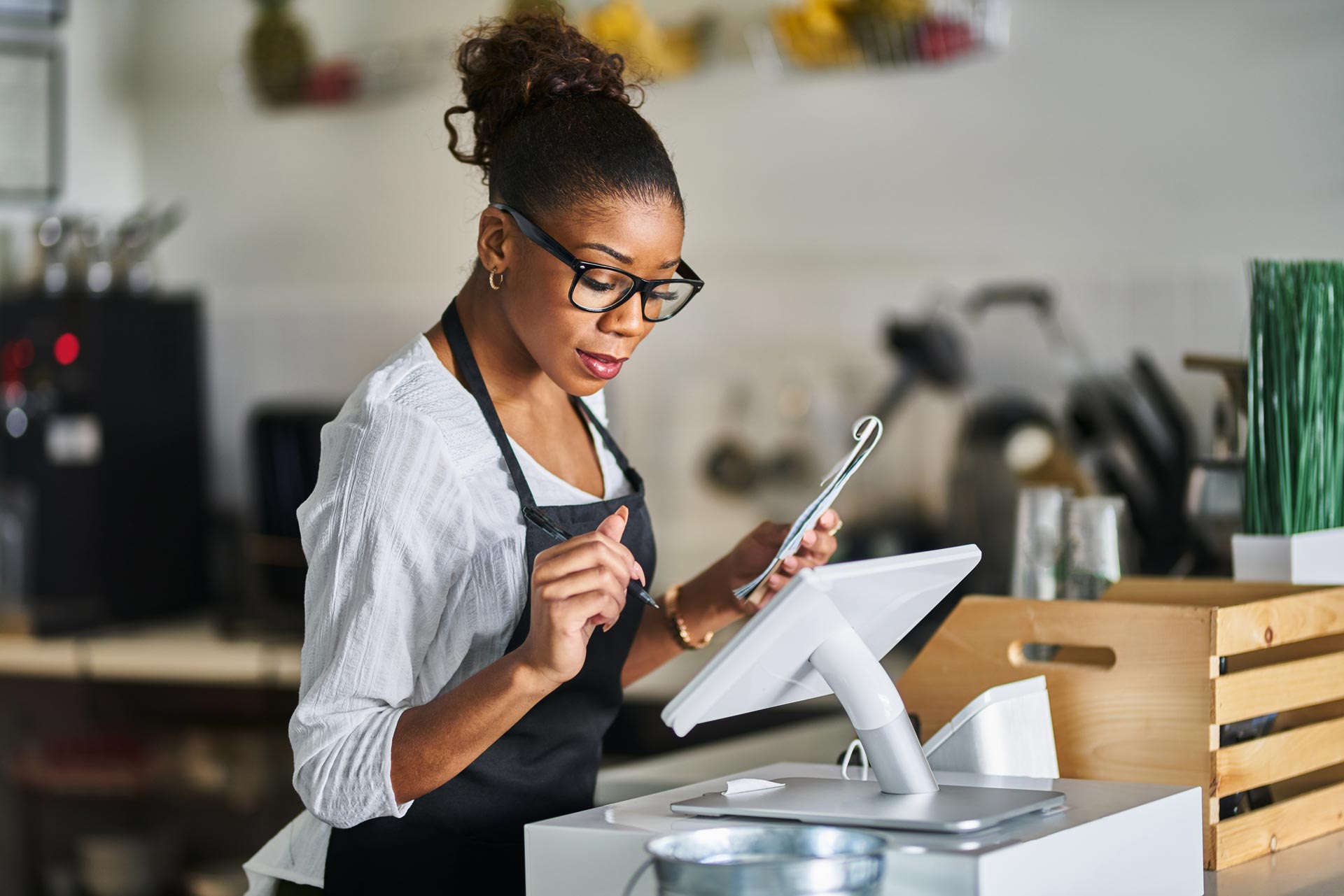 Shop Assistant Placing Order From Notepad Into Pos Point Of Sale Terminal At Register In Restaurant 2